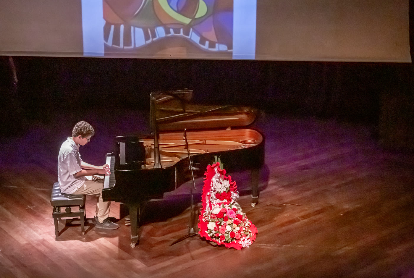 Élève au piano à queue sur la scène du concert 2023