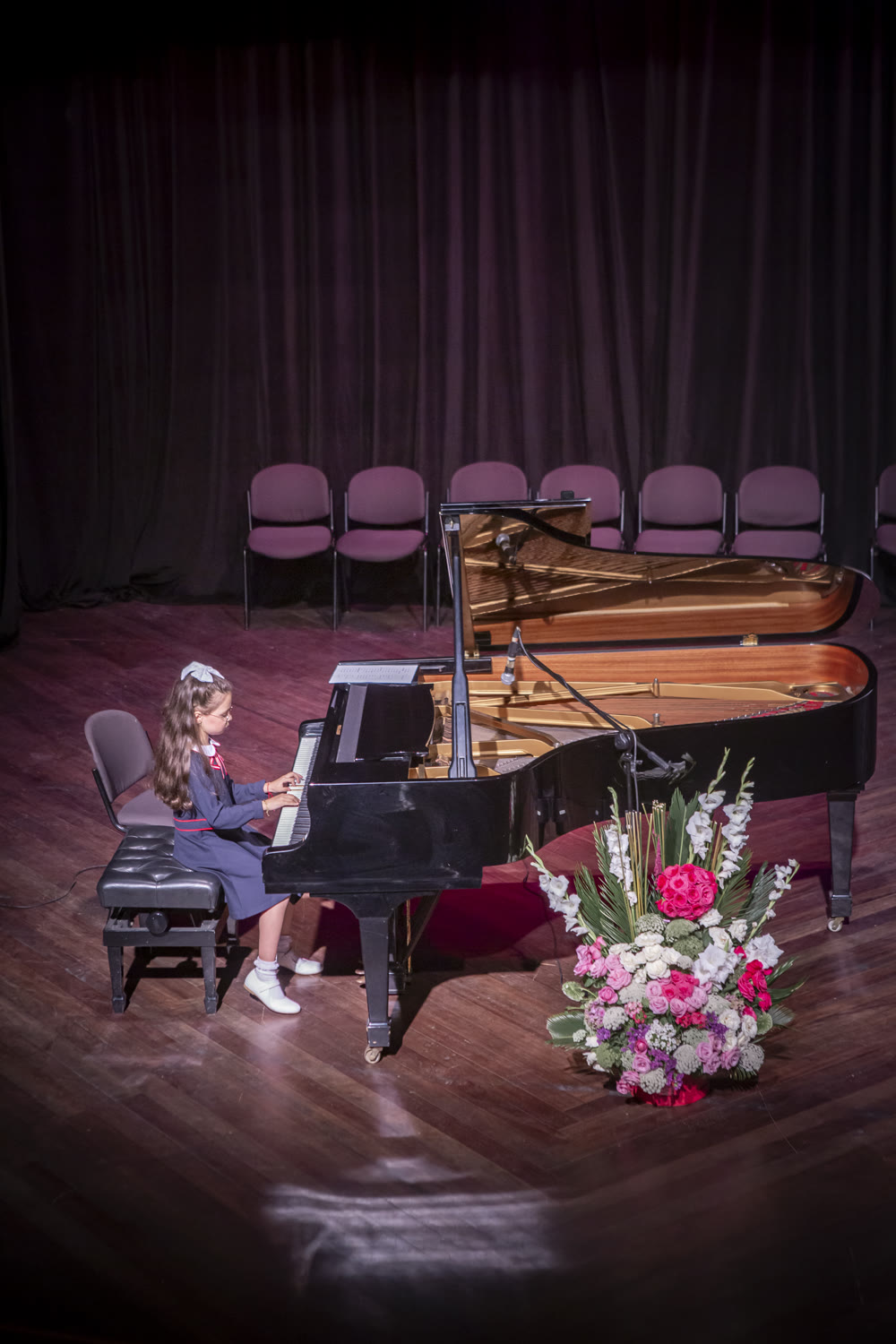 Jeune élève de l'académie au piano à queue, sur scène